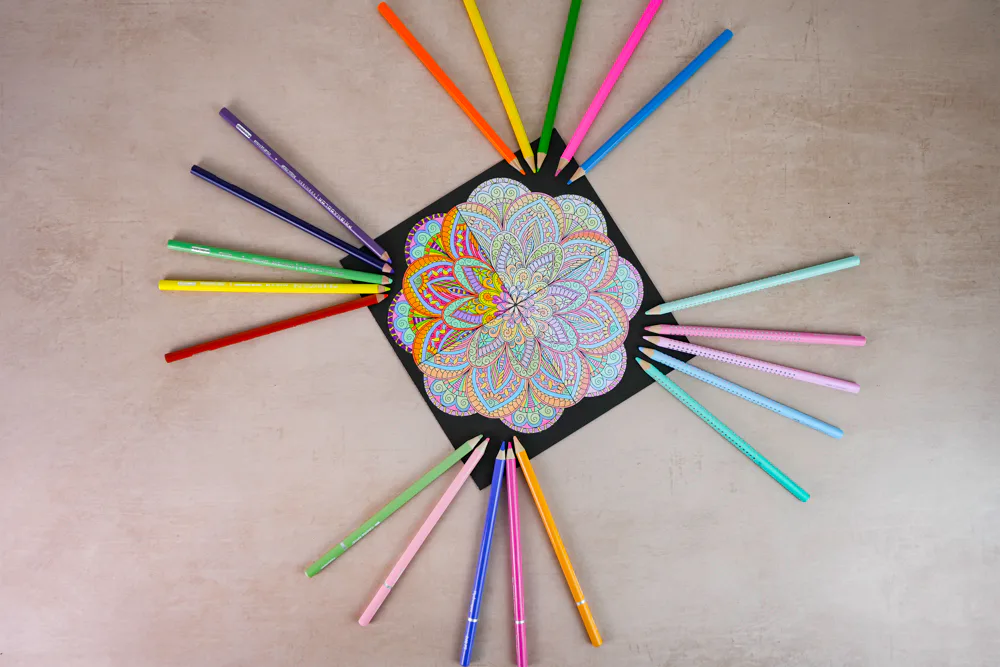 Mit vier verschiedenen Buntstift-Marken viergeteilt ausgemaltes Mandala von oben