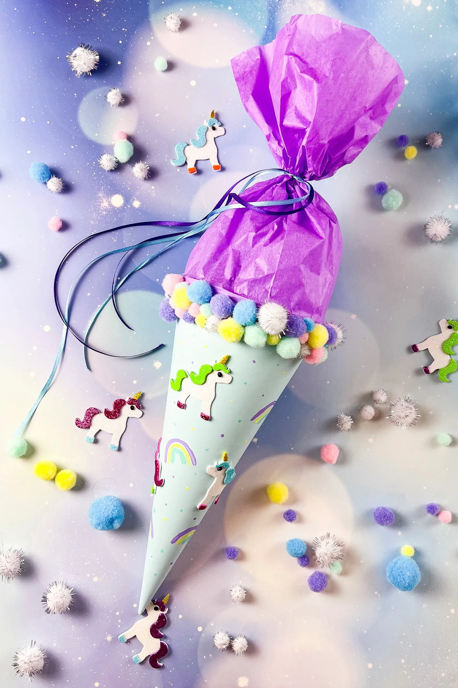 Fertige Einhorn-Schultüte mit lila Seidenpapier, Pompons und Einhorn-Stickern