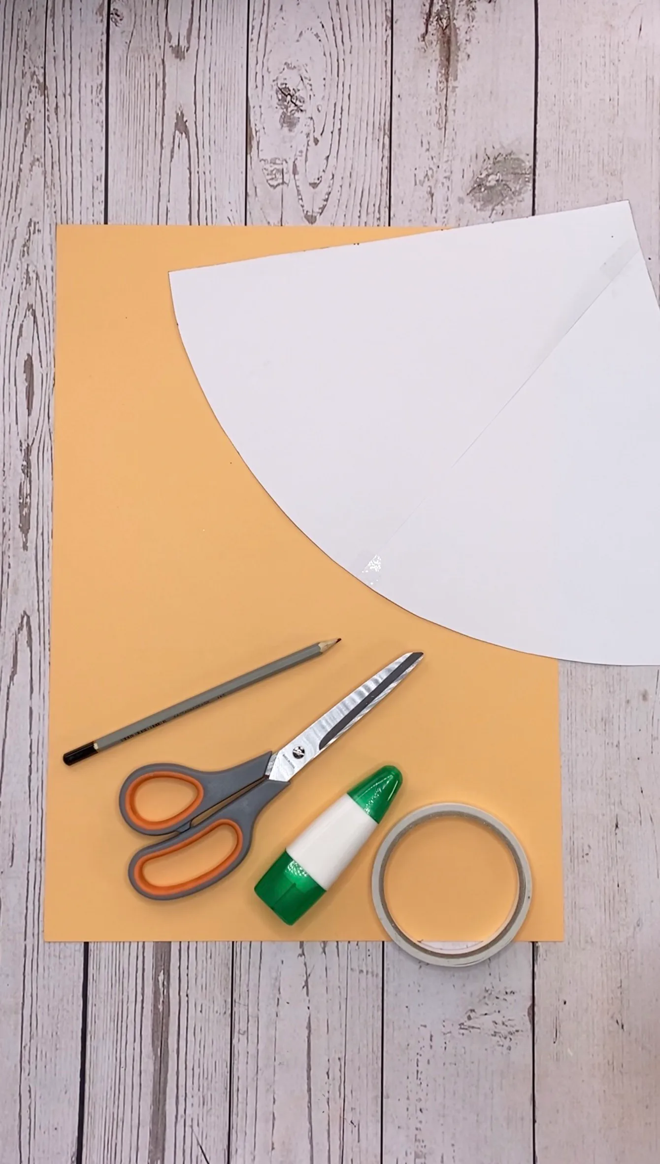 Papierschablone, Bastelpapier, Schere, Kleber und Klebeband auf dem Tisch