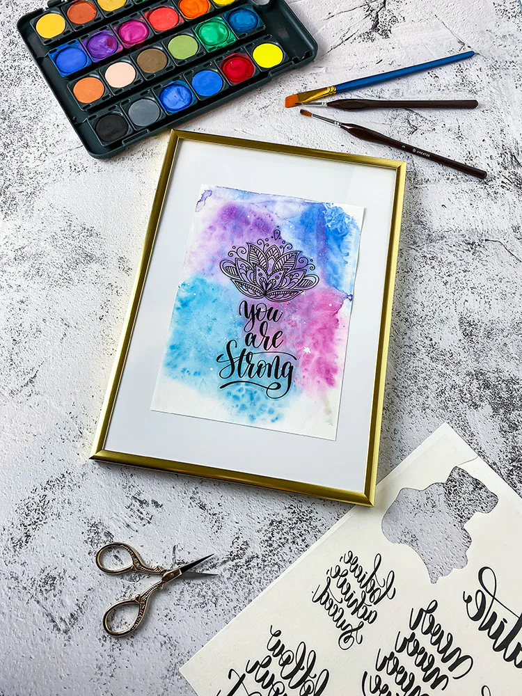 Aquarellbild mit Lotusblüten-Motiv und Schriftzug im goldenen Bilderrahmen