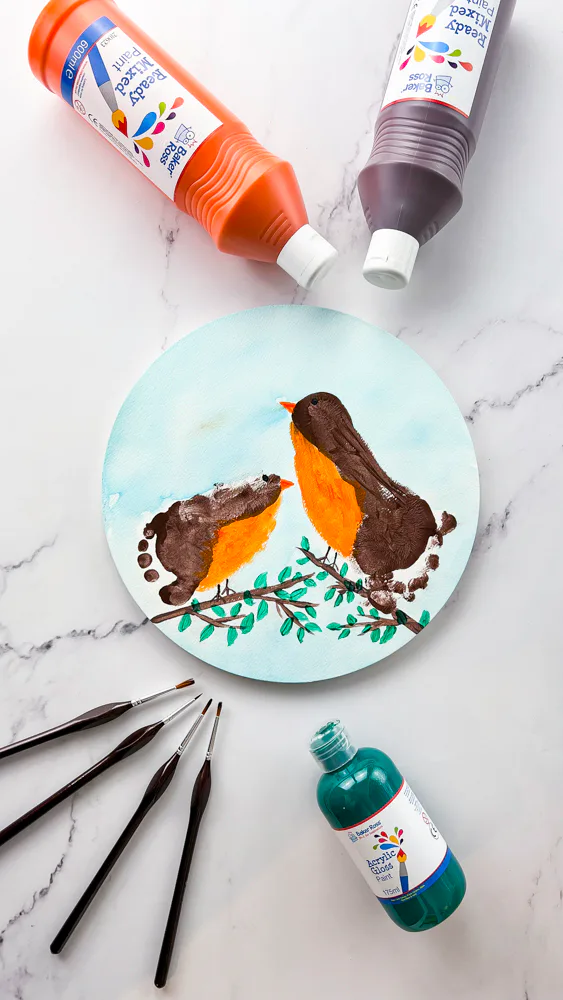 Zwei Vögel aus Fußabdrücken auf einem runden Ast gemalt