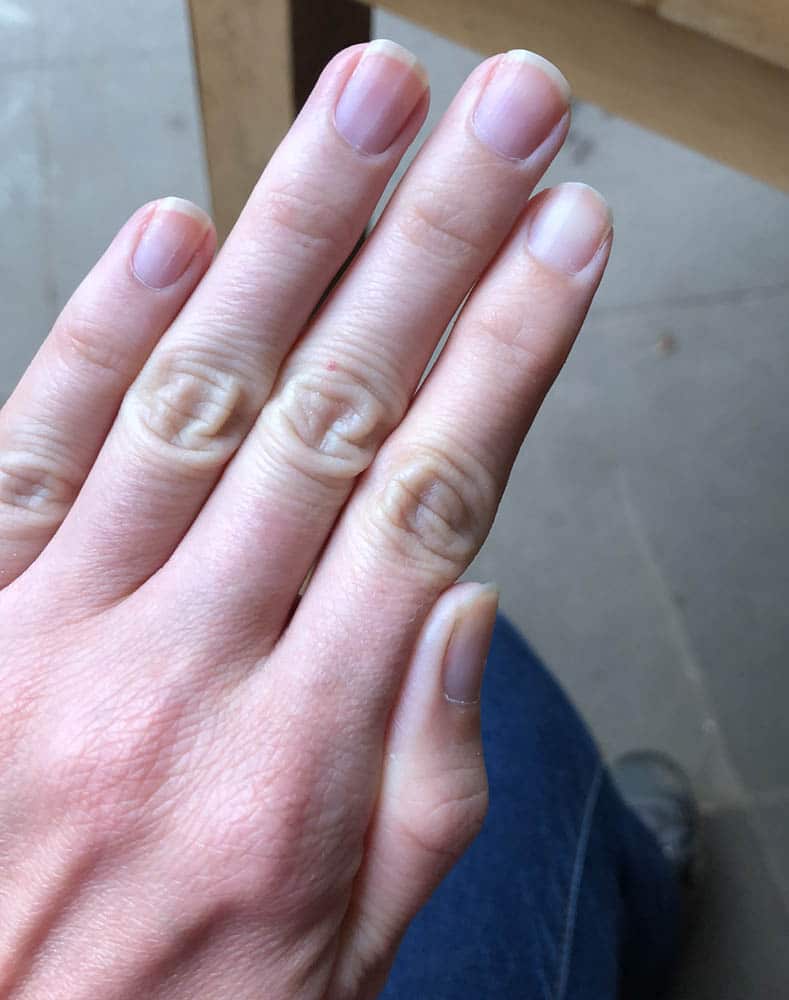 Handrücken mit natürlichen, unlackierten Fingernägeln ohne Nagelfolie