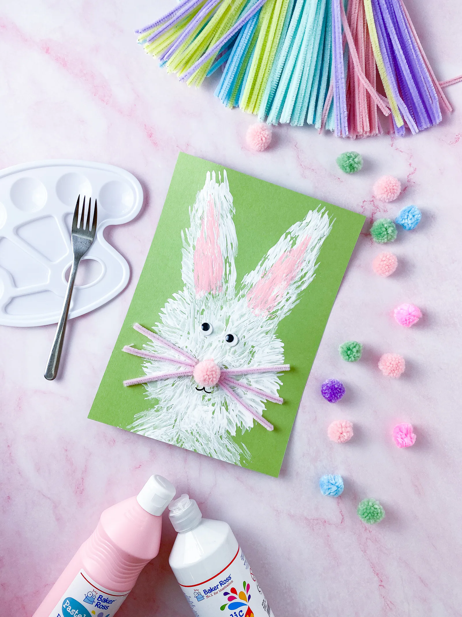 Mit Gabel gestempelter Osterhase aus weißer Farbe mit Wackelaugen und Pompon-Nase