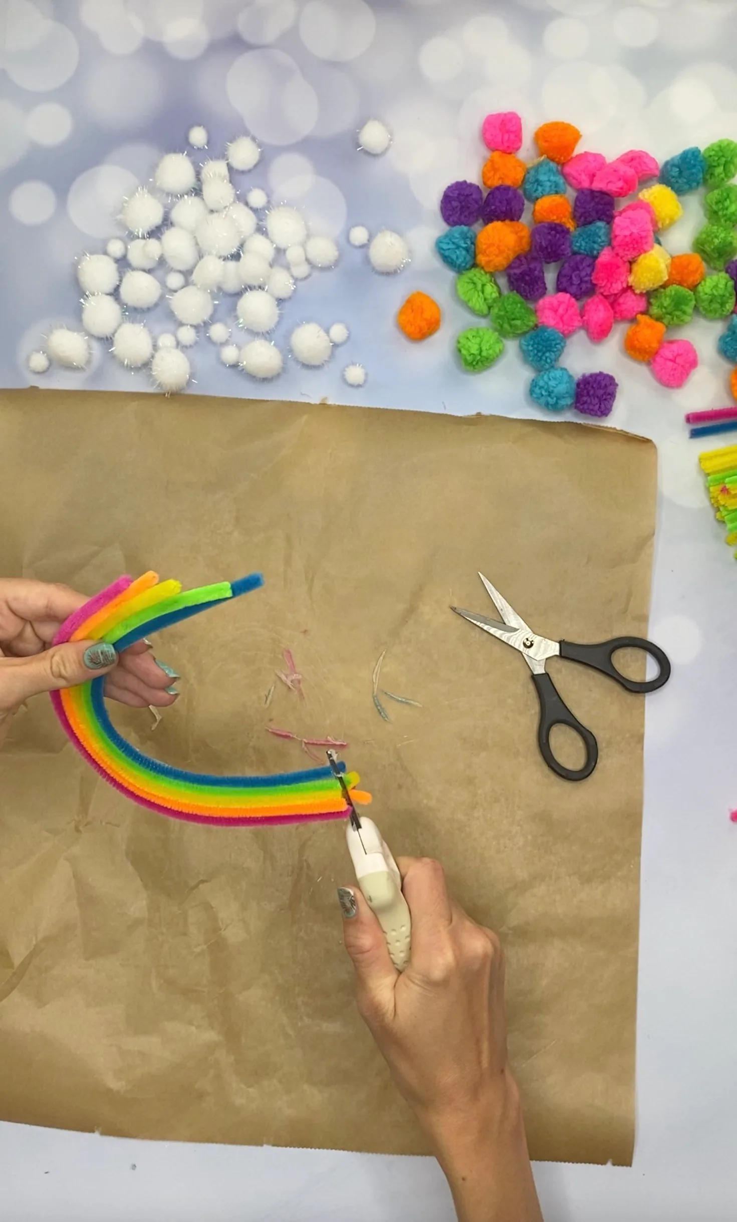 Die Ränder des Chenilledraht-Regenbogens werden mit einer kleinen Schere angeglichen