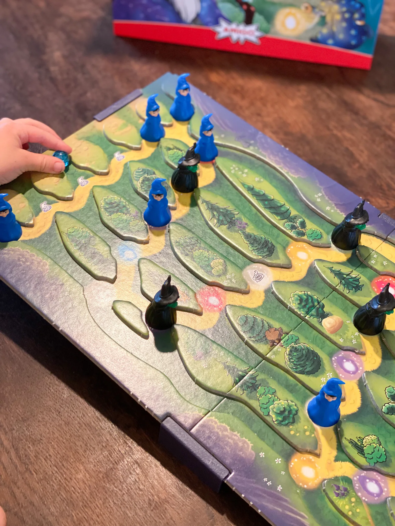 Kinderhand lässt eine Murmel über das geneigte Zauberberg-Spielbrett rollen