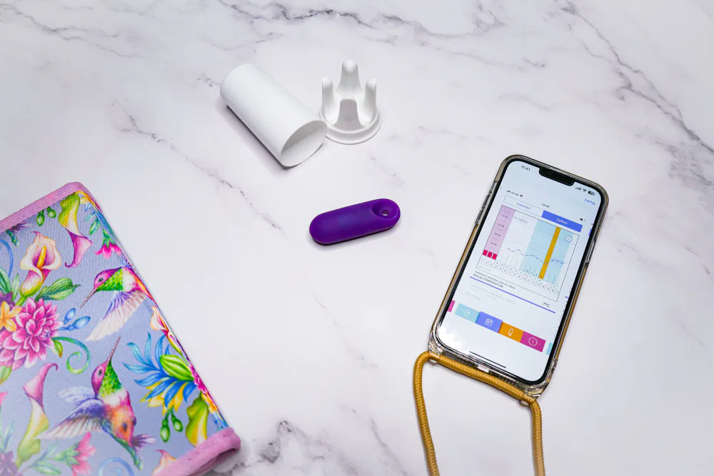 Trackle Sensor neben einem Smartphone mit Zykluskurve